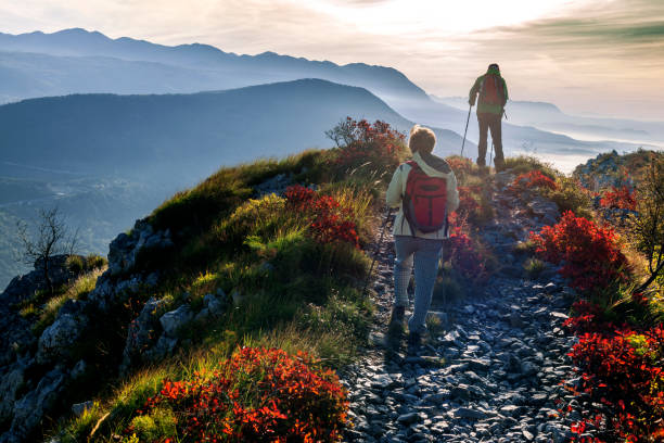 Happy Senior Couple Hiking at Autumnal Dawn in Julian Alps, Slovenia, Europe Happy senior couple hiking at autumnal dawn in southern Julian Alps, Slovenia, Europe. Nikon D3x. julian alps stock pictures, royalty-free photos & images