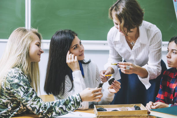 istock Teacher woman happy young students leads a lesson in class 876522130