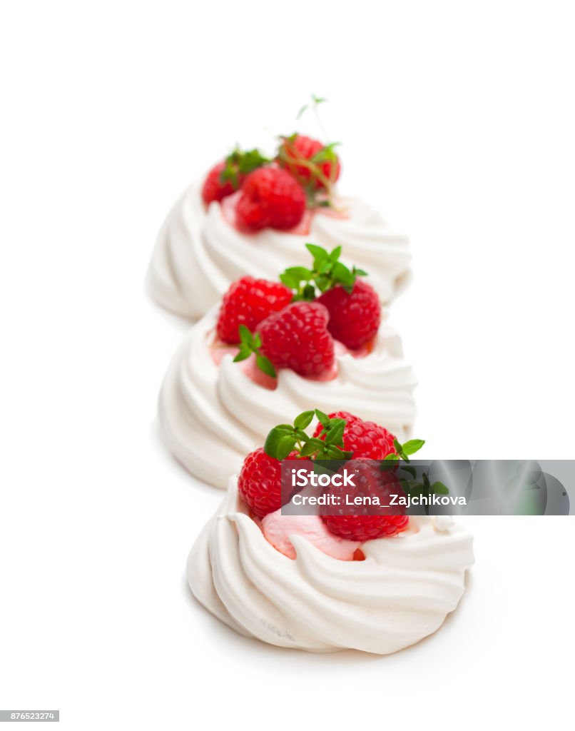 Mini  Pavlova meringue nests with berries and mint on isolated on white Berry Stock Photo