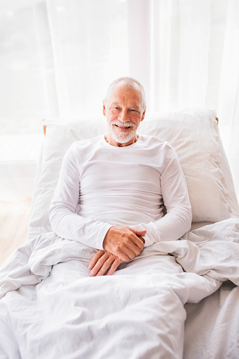 Senior hombre acostado en la cama en casa. photo