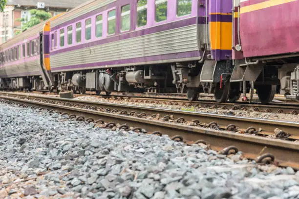 Photo of Railway train on the railroad tracks in Bangkok station. Many people in Thailand popular travel by train because it is cheaper.