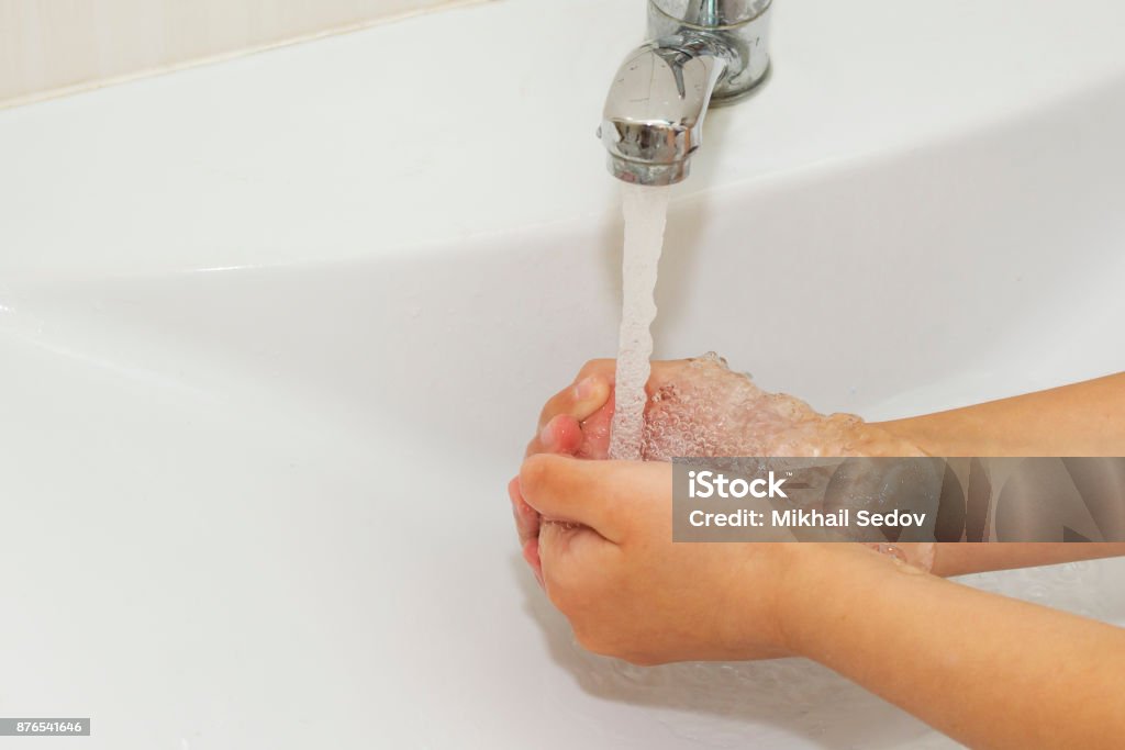 Washing of hands with soap under the crane with water Washing of hands with soap under the crane with water. Active Lifestyle Stock Photo