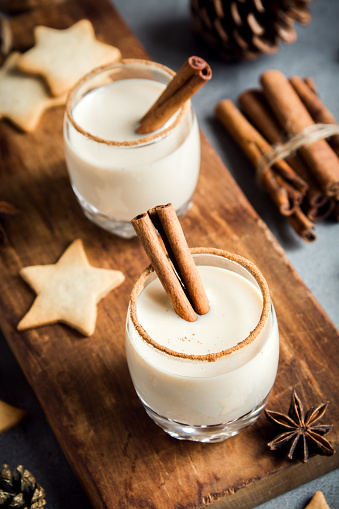 Eggnog with cinnamon and nutmeg for Christmas and winter holidays. Homemade eggnog in glasses with spicy rim.
