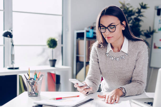 istock Young women in office using phone 876551184