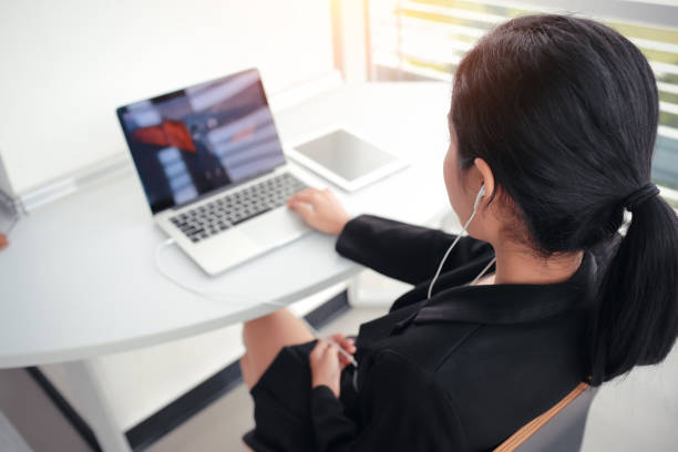istock business woman take a break from completed work by listen to music with sun light effect 876557370