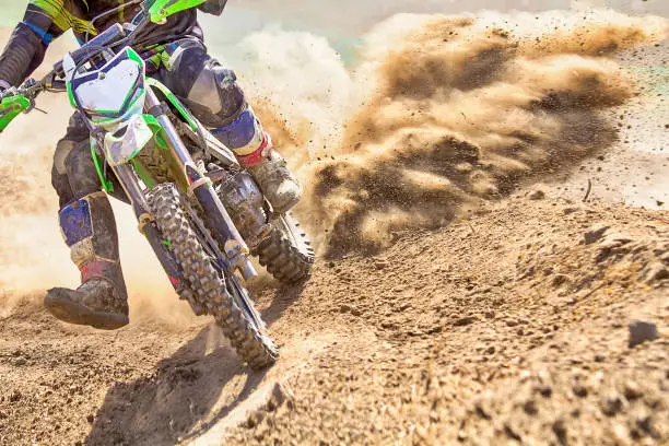 Photo of motocross racer accelerating speed in track