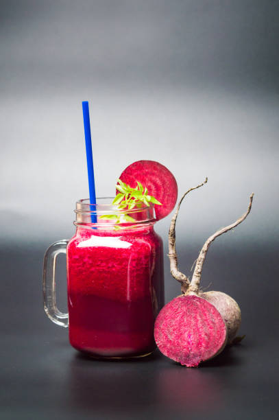 istock Healthy beet smoothie in jars on dark background 876561554