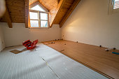 empty room with red toolbox and wooden flooring during renovations