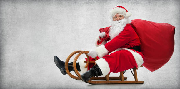 Santa Claus on his sledge Santa Claus on his sledge with a bag full of Christmas gifts animal sleigh photos stock pictures, royalty-free photos & images