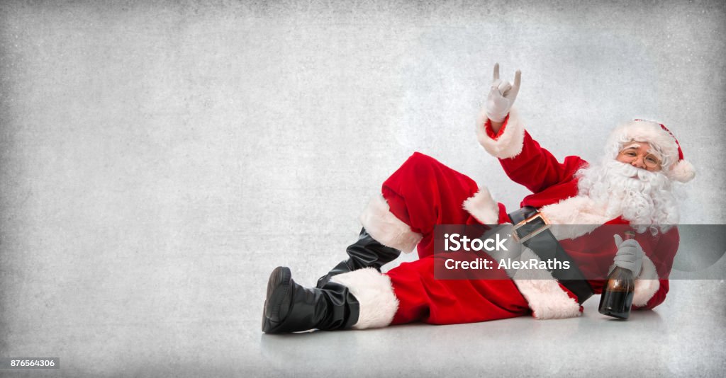 Felice Babbo Natale sdraiato sul pavimento con una bottiglia di vino - Foto stock royalty-free di Babbo Natale