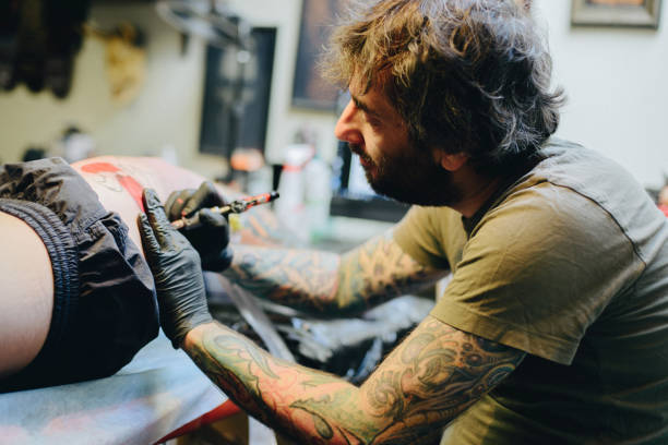 istock Professional artist making tattoo on the leg 876569754
