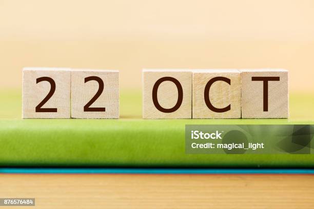 Wooden Cube Shape Calendar For Oct 22 On Green Book Table Stock Photo - Download Image Now