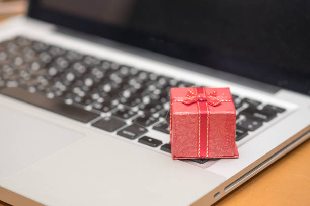 istock Technology and online shopping concept. Close up of red gift box on laptop computer. 876576872
