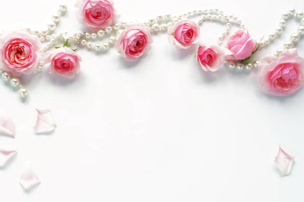 istock pink roses and beads on a white background.Top view. Copy space 876580530