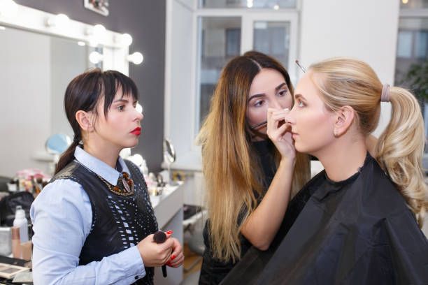 makeup tutorial lesson makeup teacher with her student girl. Makeup tutorial lesson at beauty school. Make up artist work in her studio. Portrait of visagiste applying makeup on the eyes. Master class beauty spa stock pictures, royalty-free photos & images