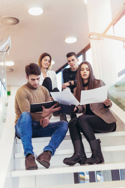 istock Group of students studying on steps of school building 876587082