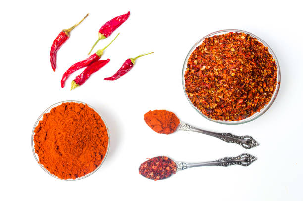 молотый красный перец в изолированной миске - chili pepper стоковые фото и изображения