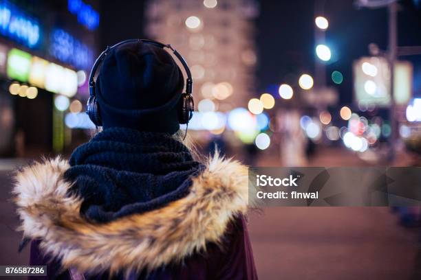 Girl Walking Through Night City Street Listening To The Music Stock Photo - Download Image Now