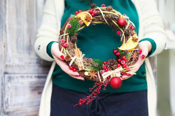 istock Christmas wreath in young womans hands 876590038
