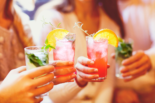 Jóvenes, hombres y mujeres bebiendo cócteles en partido photo