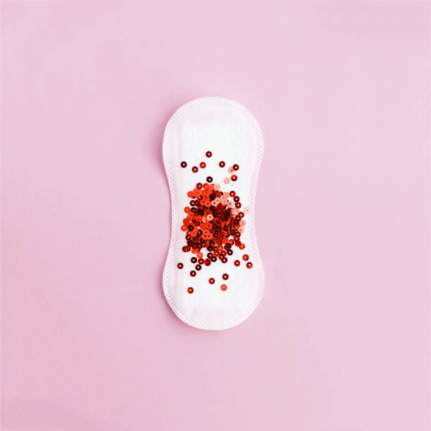 Menstrual pad with red glitter on pastel background stock photo