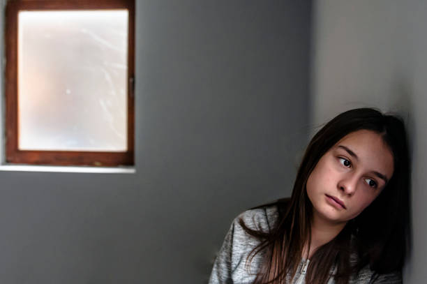 istock Depressed teenager sitting lonely 876597730