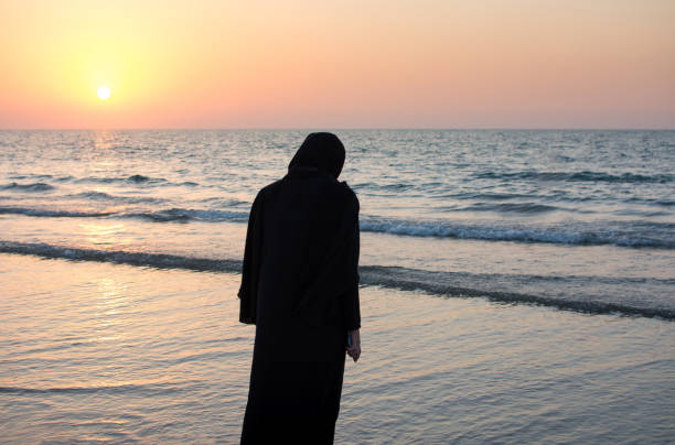 istock Woman in hijab standing on the beach 876601358