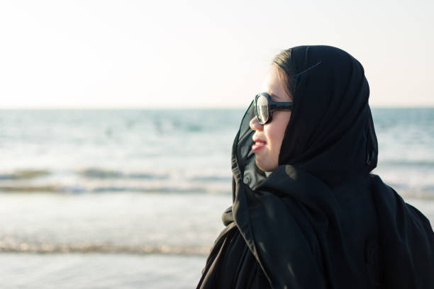 istock Woman in hijab standing on the beach 876605200