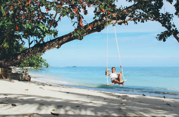 istock Beautiful girl on the swing on the beach 876608536