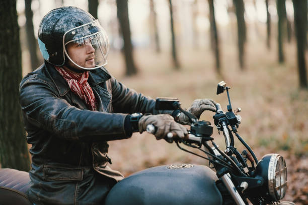 istock Man and old custom cafe-racer Motorcycle on forest 876612362