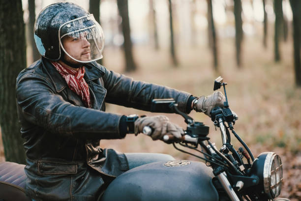 istock Man and old custom cafe-racer Motorcycle on forest 876612556