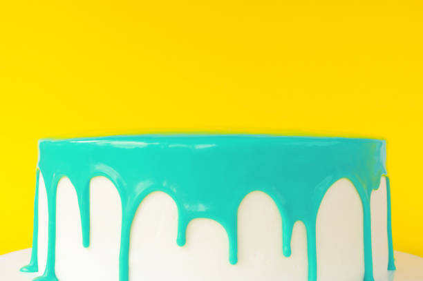 istock Cake baking with cyan glaze on yellow background. 876613520