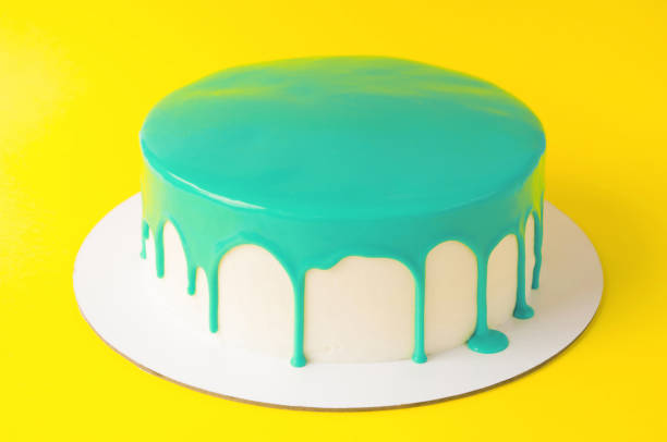 istock Cake baking with cyan glaze on yellow background. 876614616