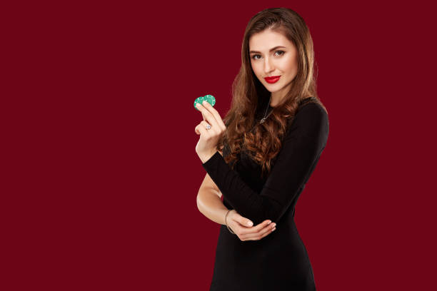 Pretty long hair woman in black dress holding chips for gambling stock photo