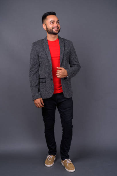 istock Young bearded Indian businessman against gray background 876616706