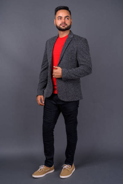 istock Young bearded Indian businessman against gray background 876616796