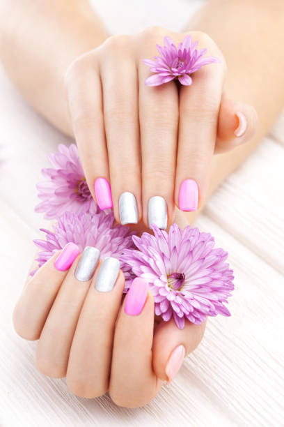 istock pink manicure with chrysanthemum flowers. spa 876625486