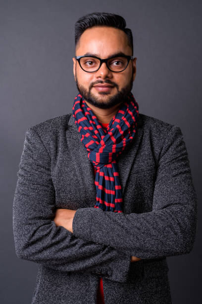 istock Young bearded Indian businessman against gray background 876625508