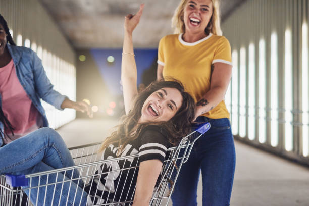 istock Girlfriends playing with a shopping cart together at night 876625626