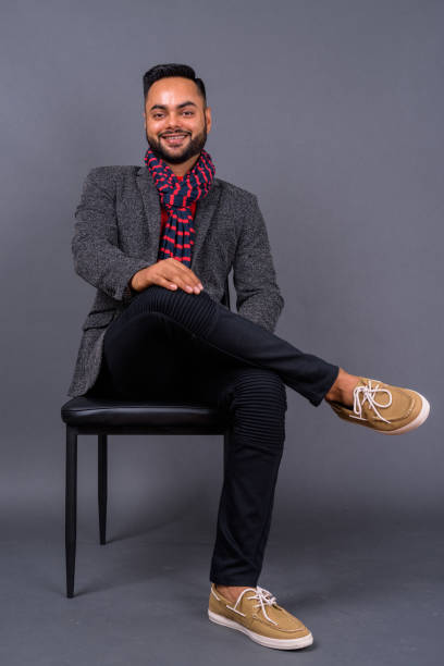 istock Young bearded Indian businessman against gray background 876625830