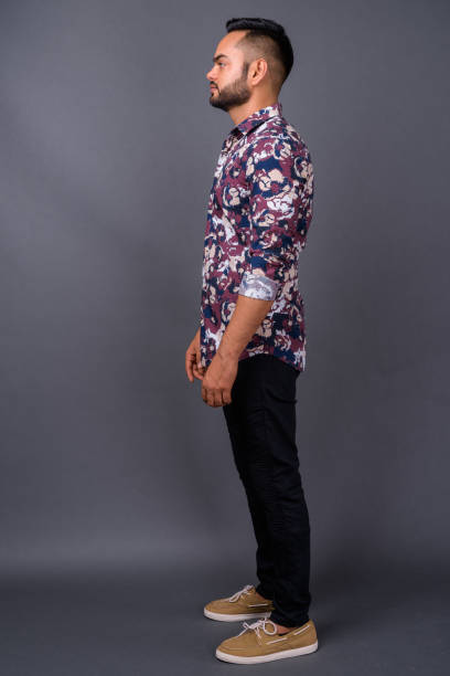 istock Young bearded Indian man against gray background 876626386