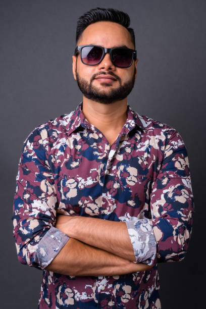 istock Young bearded Indian man against gray background 876629172