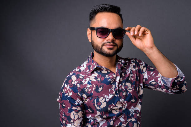 istock Young bearded Indian man against gray background 876629174
