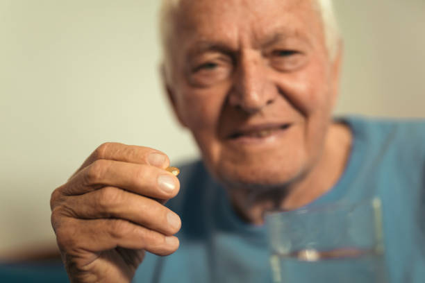 istock Senior Man Sitting On Bed At Home Taking Medication 876629210