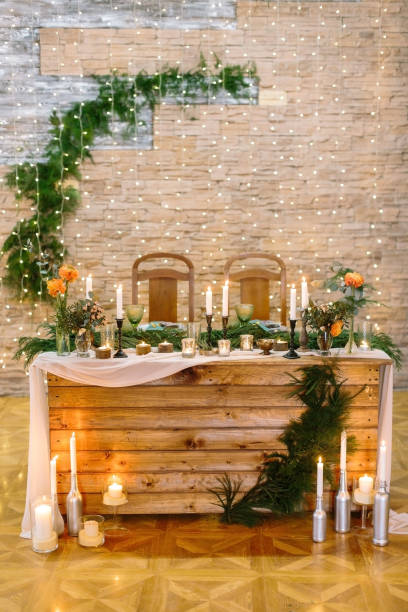 istock celebrating, restaurant, design concept. wedding table for two newlyweds decorated with lots of candles in holders and in silver bottles, flowers and branches of conifers 876633534