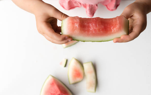 istock Little girl's hands holding watermelon slice 876635192