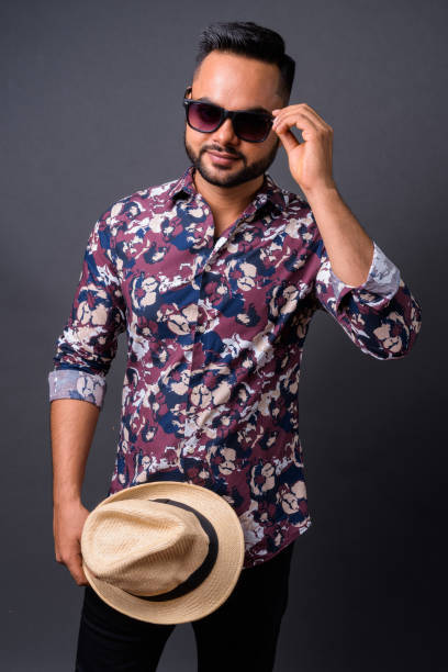 istock Young bearded Indian tourist man against gray background 876641878