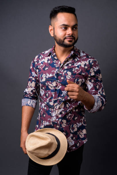istock Young bearded Indian tourist man against gray background 876641880