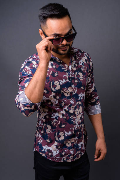istock Young bearded Indian man against gray background 876641926