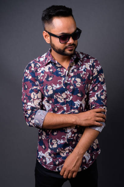 istock Young bearded Indian man against gray background 876641984